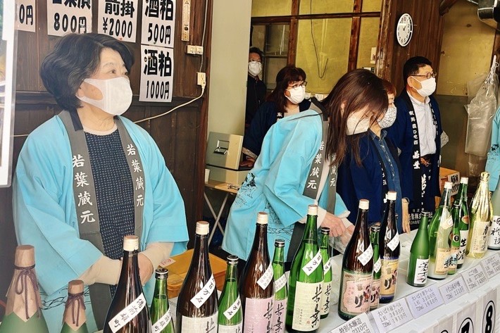 日本酒の販売コーナーで接客する女性