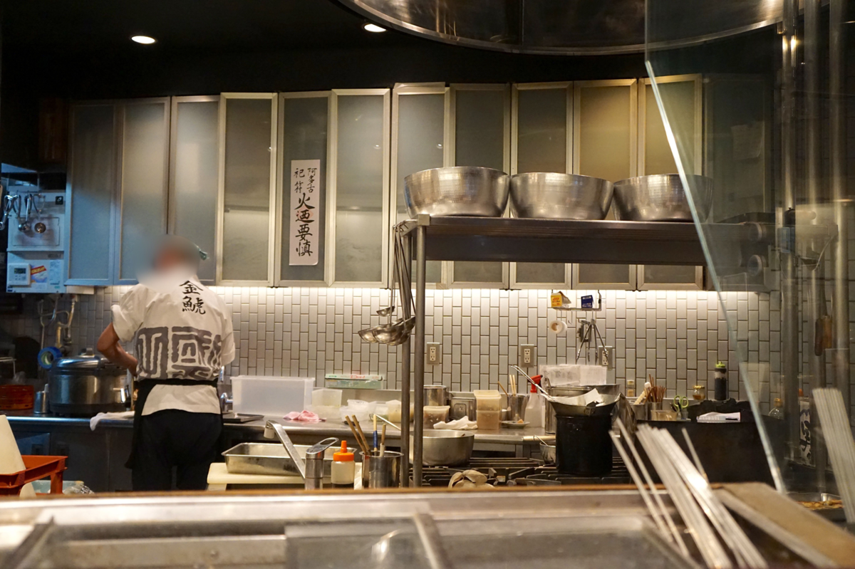 厨房で調理をする料理人