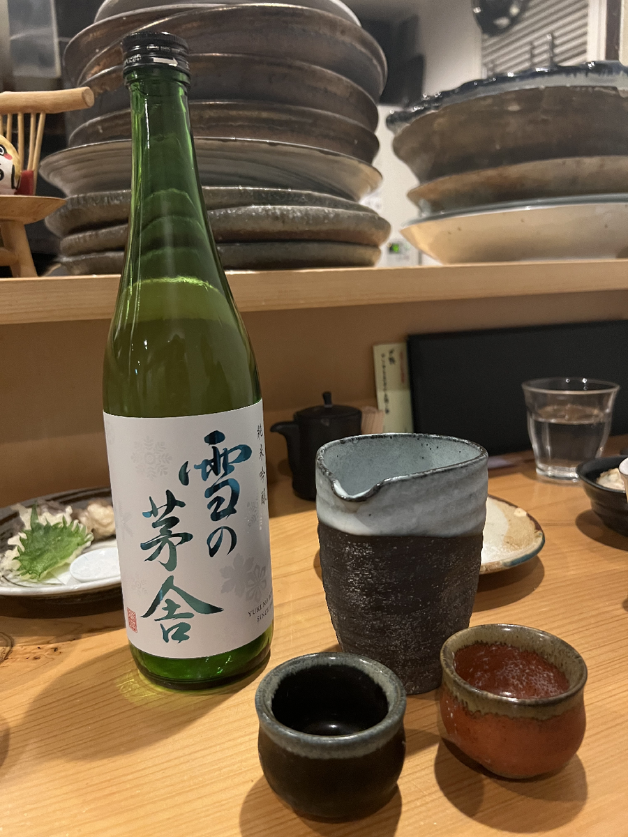 テーブルの上にある日本酒の一升瓶とお猪口