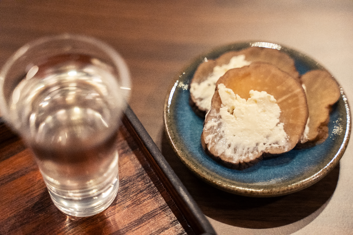 日本酒が入ったお猪口とつまみ