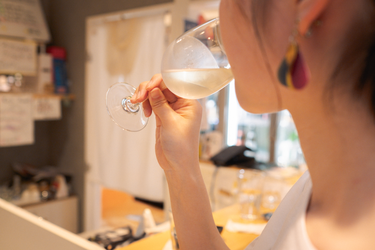 ワイングラスで日本酒を飲む女性