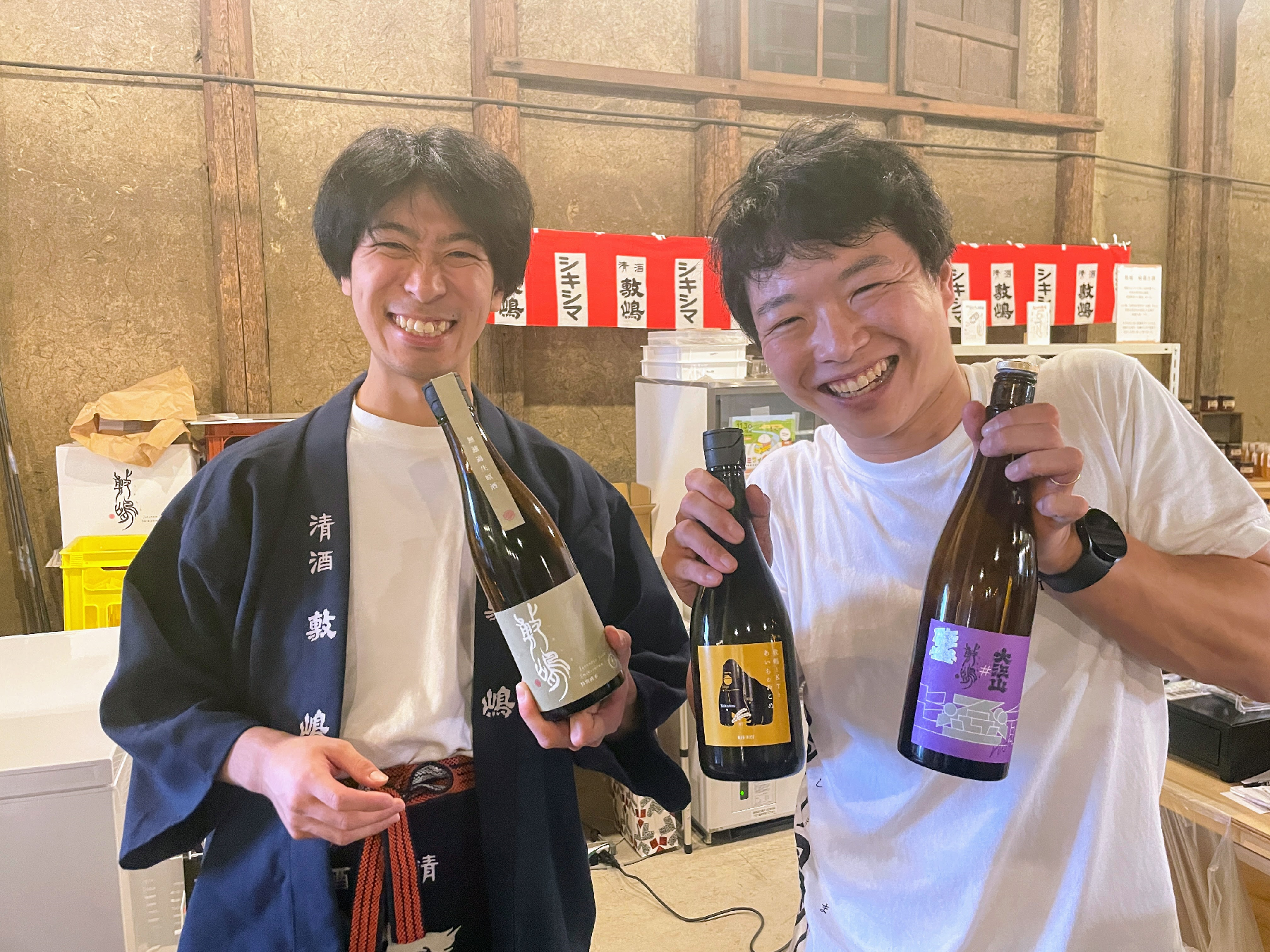 日本酒の瓶を手に持って笑顔の男性2人