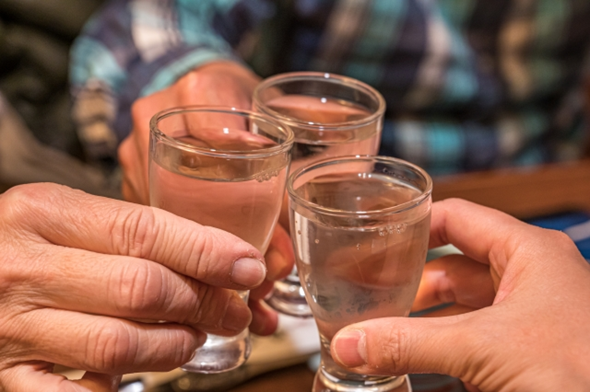 日本酒の入ったグラスで乾杯する様子