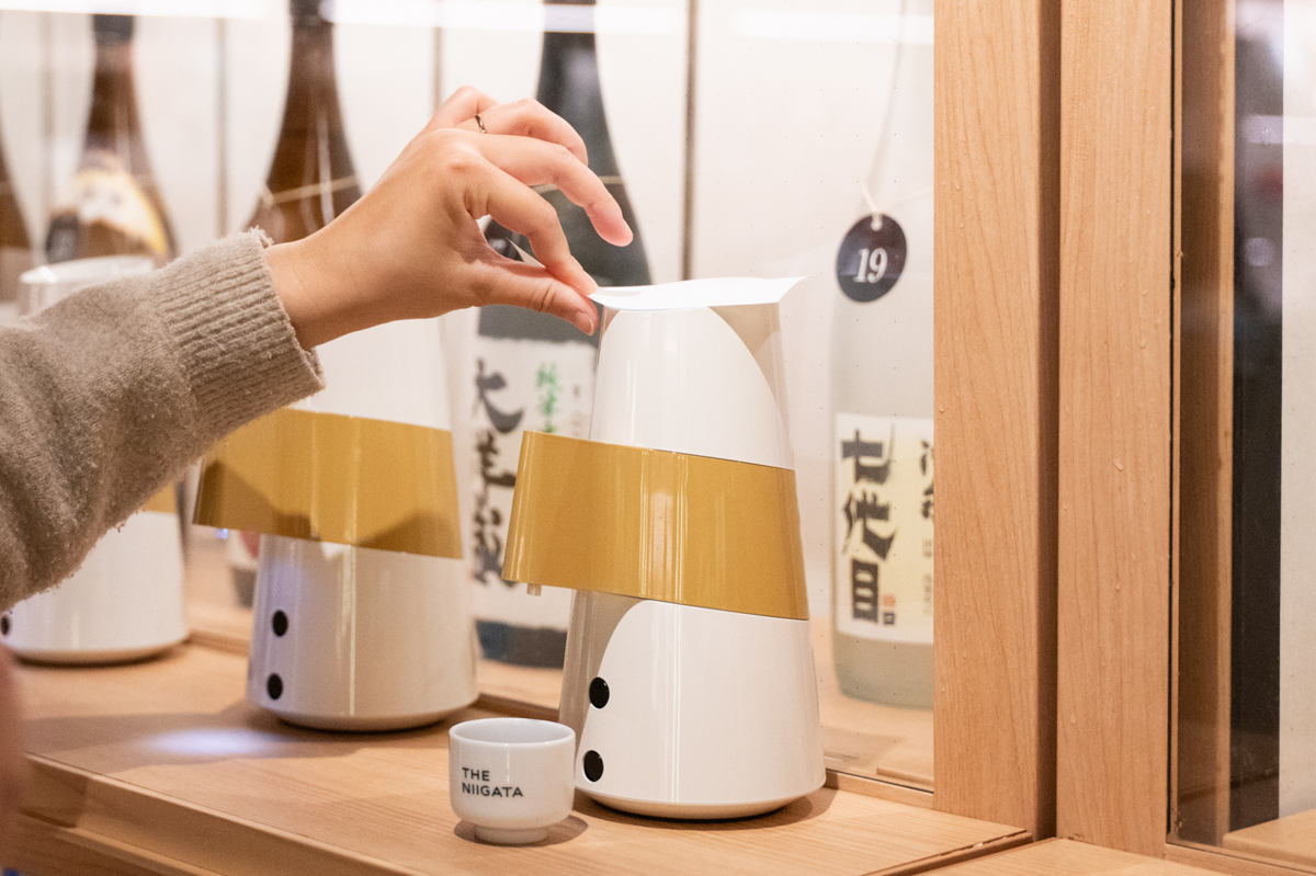 THE NIIGATAの試飲機「のまっせ」で試飲する手元