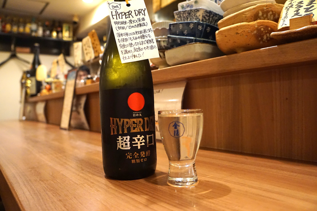 日の丸 HYPER DRY 超辛口の瓶とお酒が入ったグラス