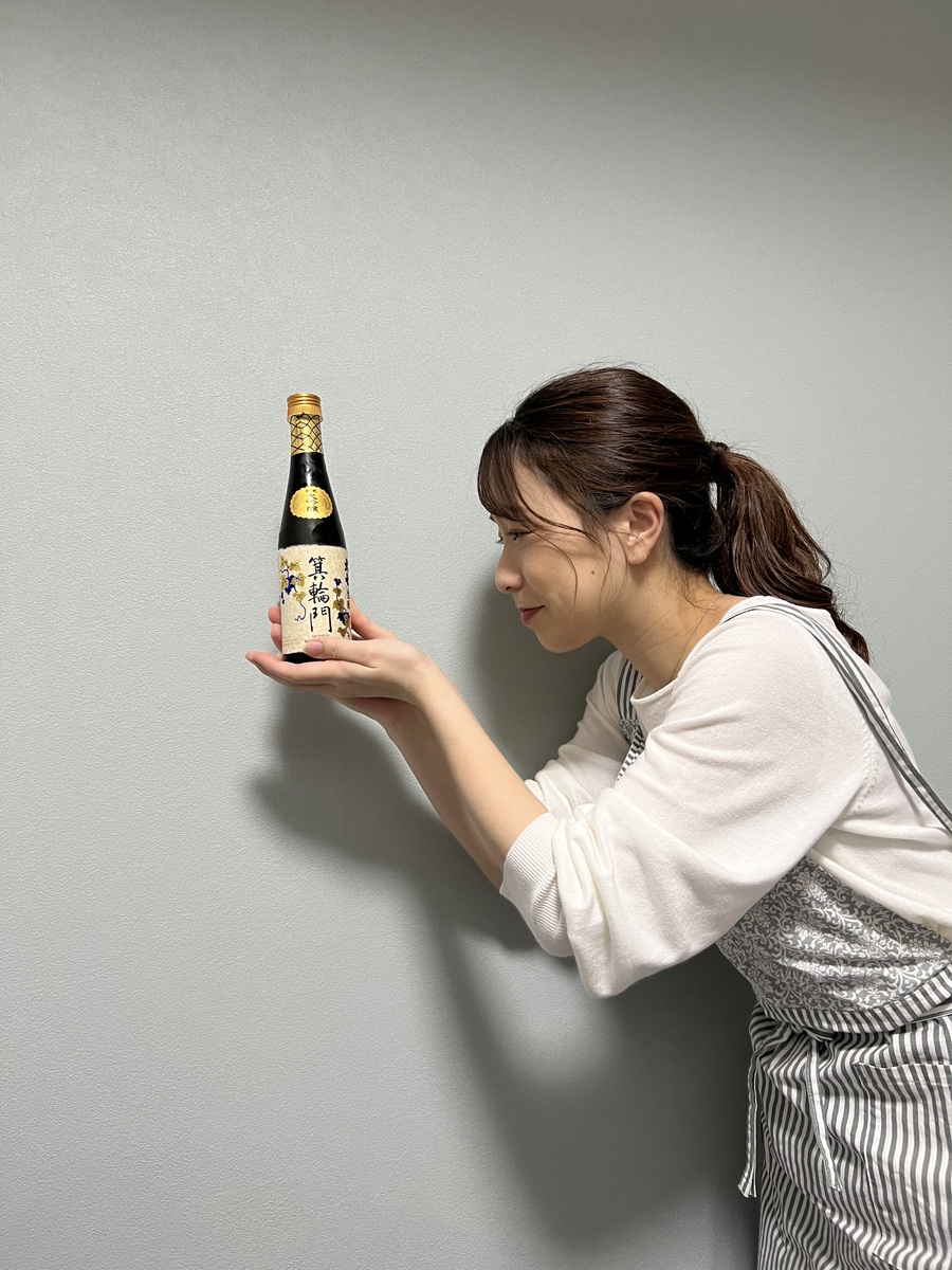 日本酒の瓶を掌に載せる女性