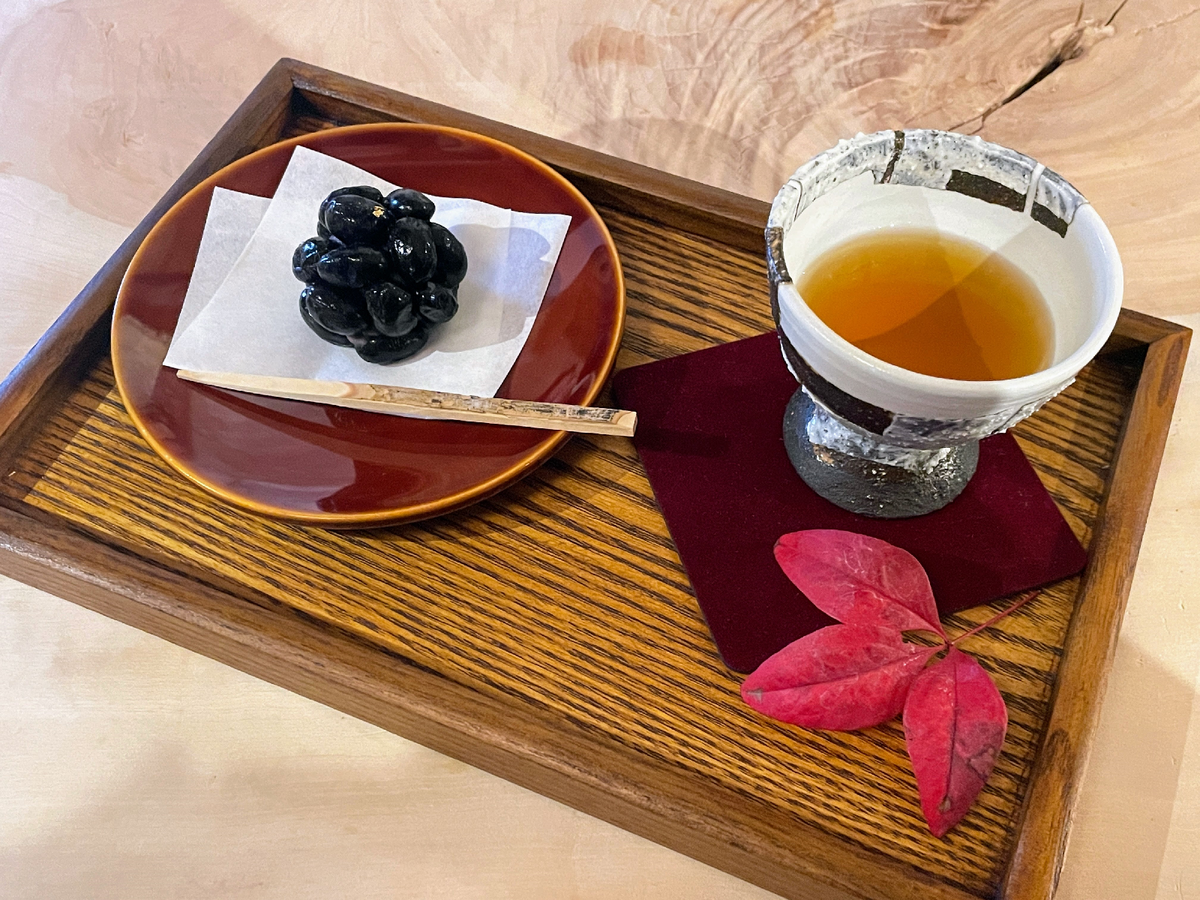 木製の盆にのった和菓子と日本酒