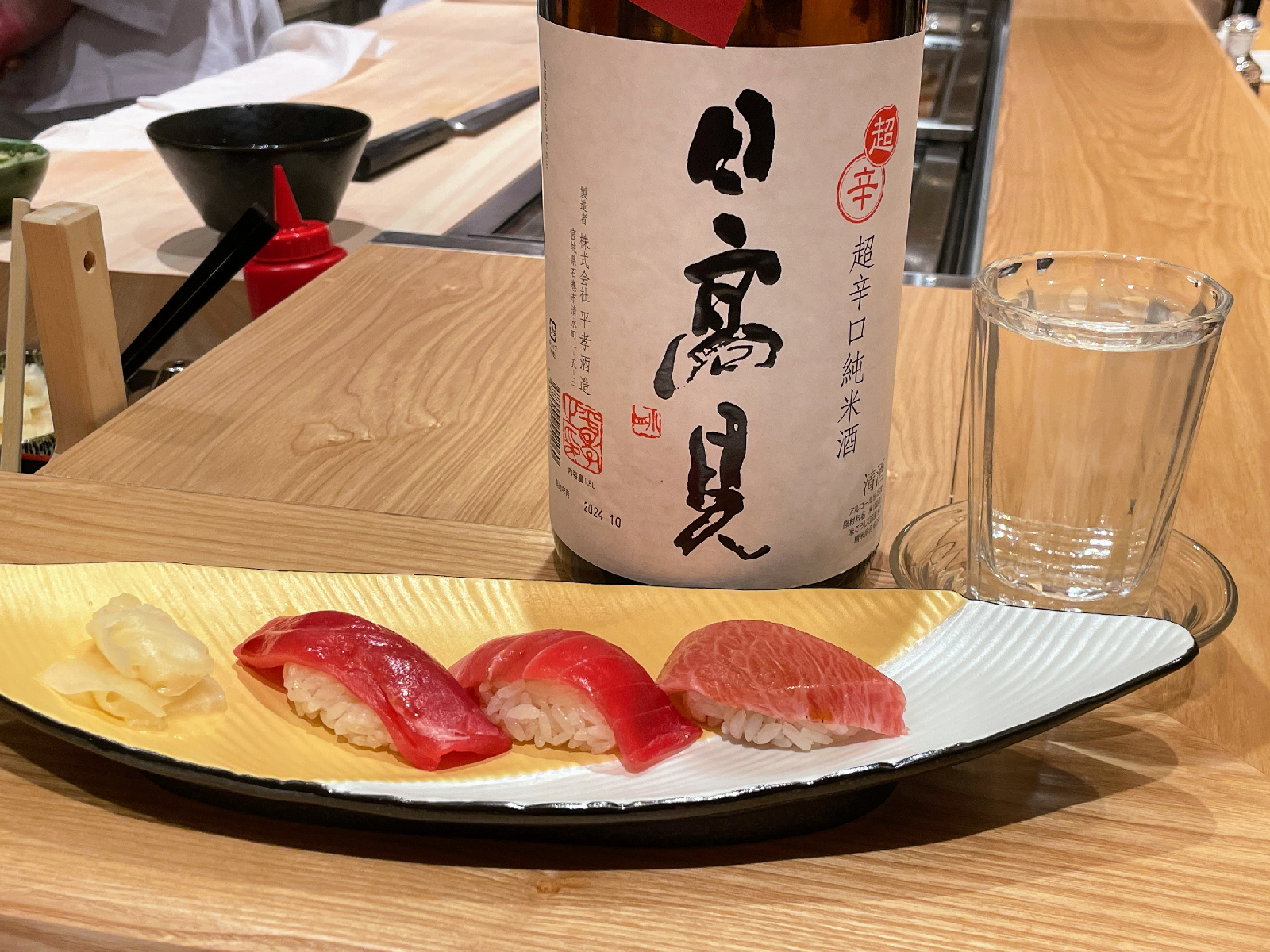 寿司ののった皿と日本酒の瓶