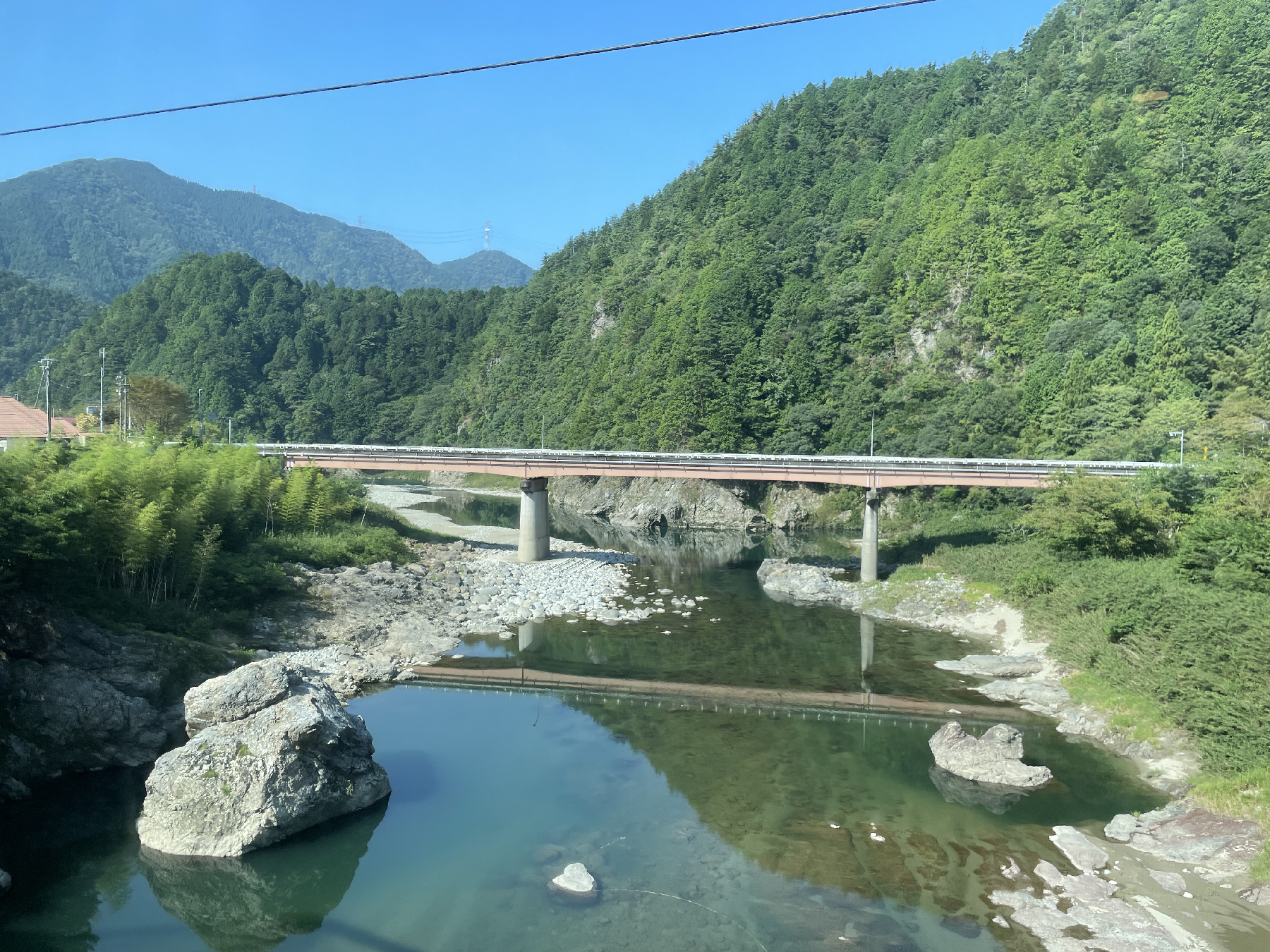 山の間を流れる川に橋が架かっている