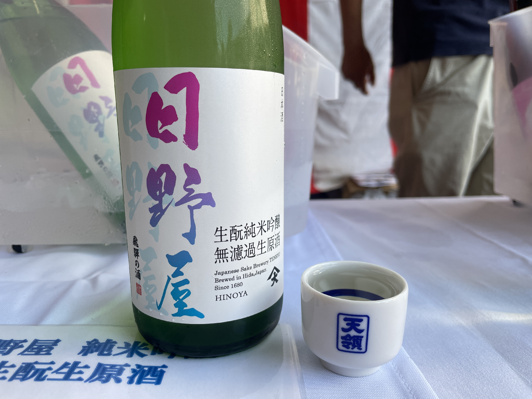 カラフルな文字のラベルの日本酒とお猪口