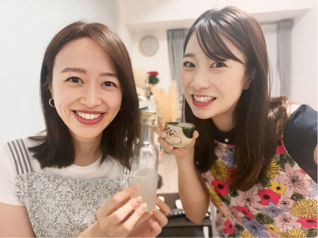 日本酒を手に持って笑顔の女性2人