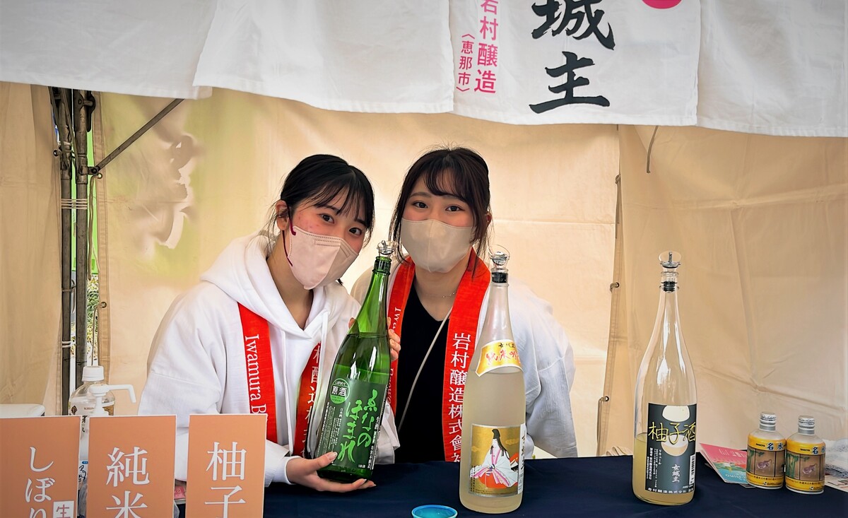 ハッピを着て日本酒を持つ女性2人