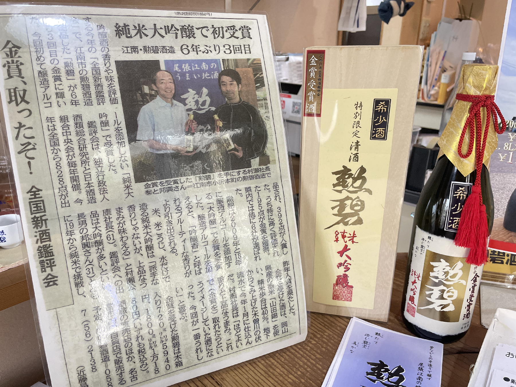 新聞記事の切り抜きと日本酒が飾ってある