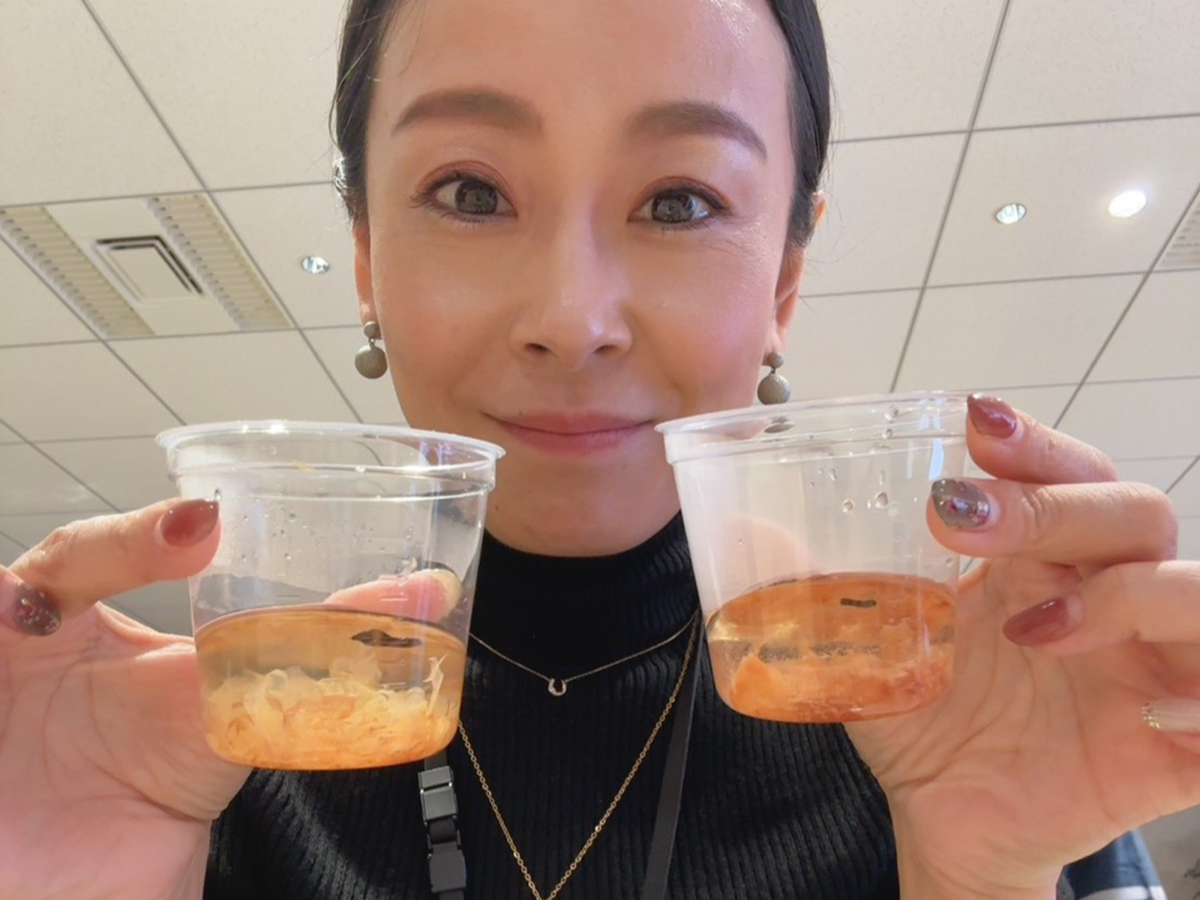 日本酒カップを両手に持つ女性