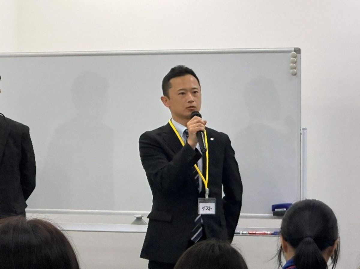 マイクを持って話をする男性