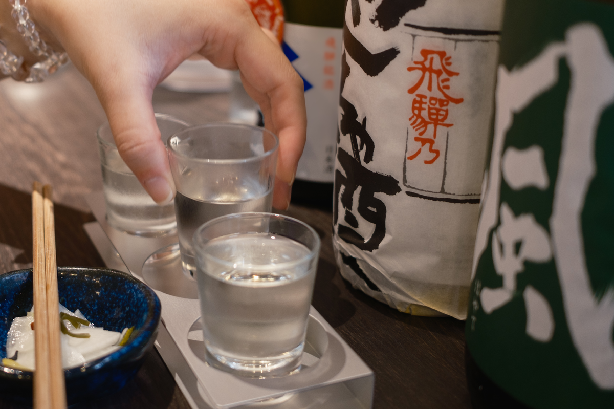 日本酒飲み比べをする女性の手元