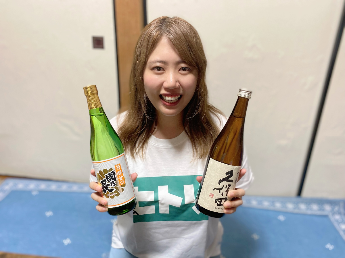 両手に日本酒の瓶を持った女性