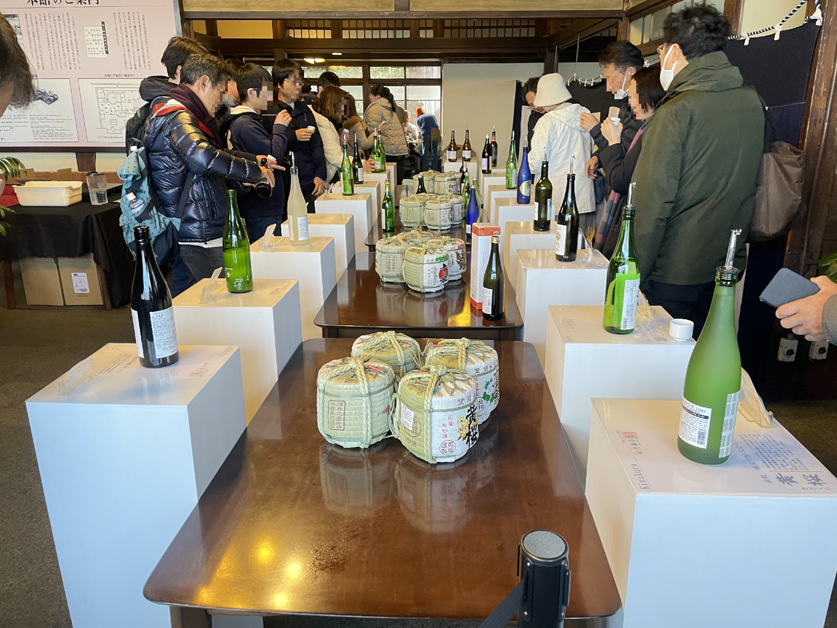 台の上に並んだ日本酒を飲み比べる人