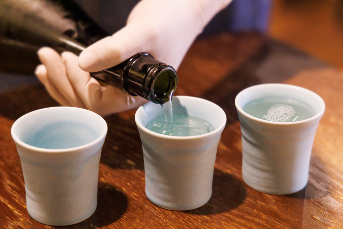 日本酒をおちょこに注ぐ手元