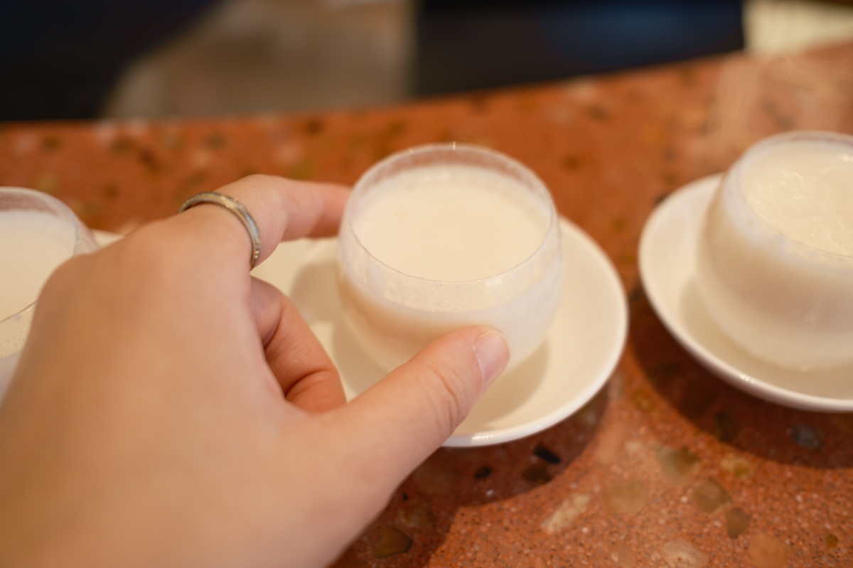 どぶろくが入ったおちょこを掴む手元