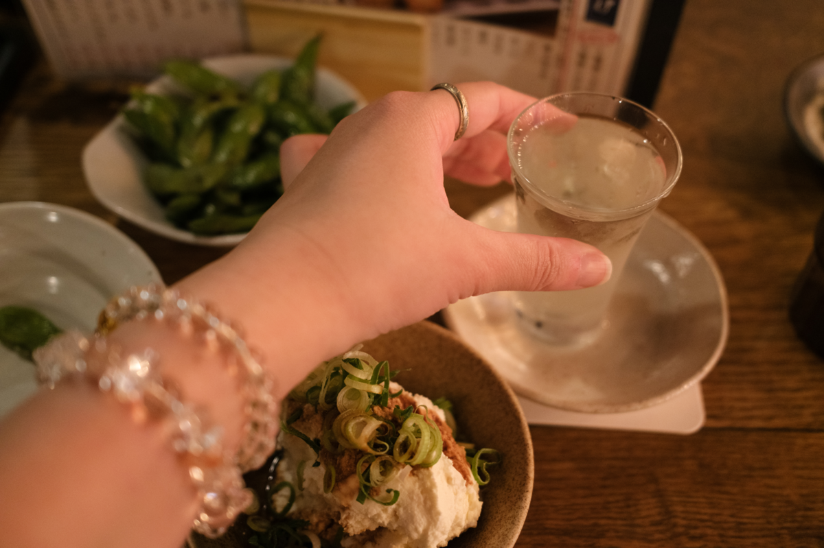 日本酒とおつまみを楽しむ女性の手元