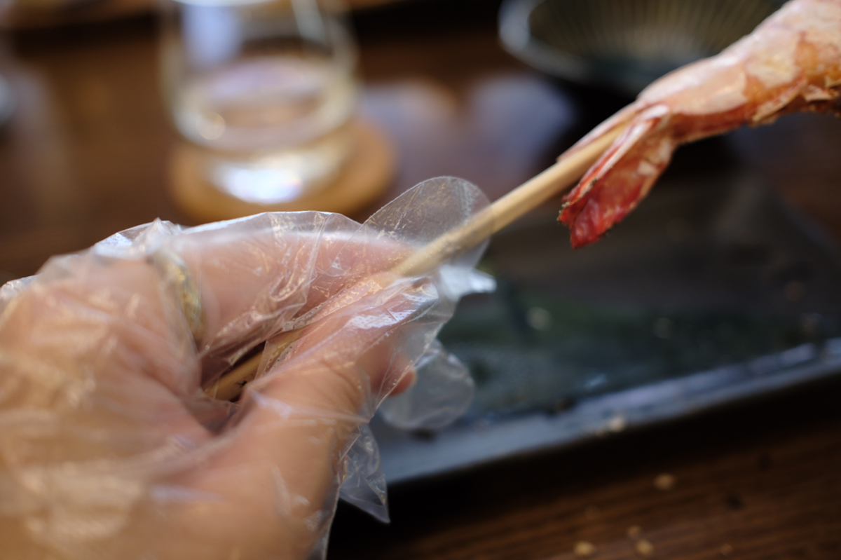 特大エビと一緒に提供される手袋