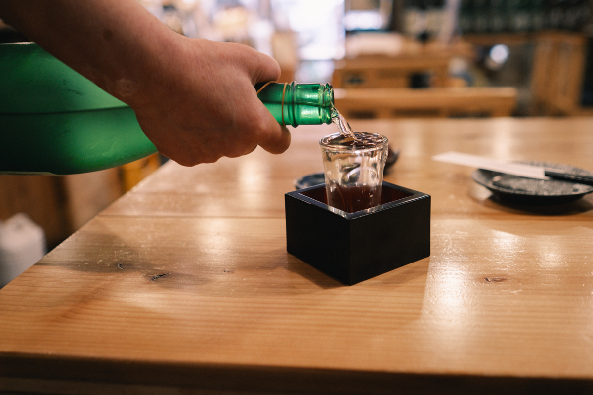 日本酒の瓶からグラスに注ぐ様子