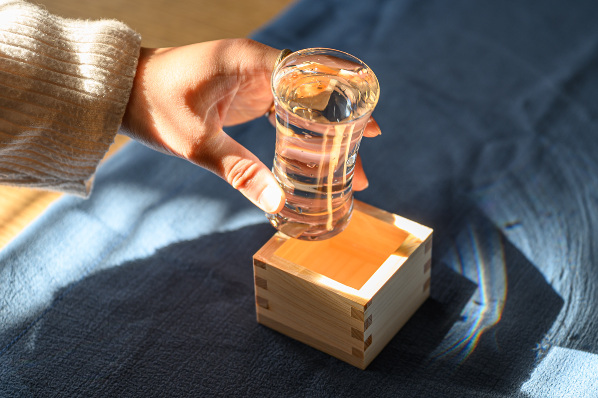 日本酒が入ったグラスを持つ手元