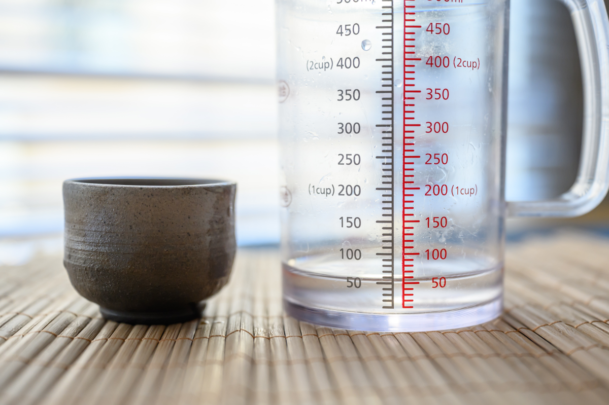 陶器製のおちょこに入る日本酒の量を計量する様子