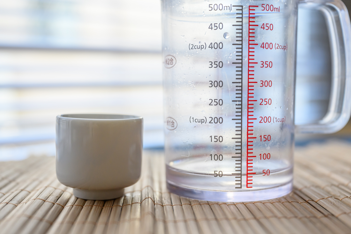 磁器製のおちょこに入る日本酒の量を計量する様子