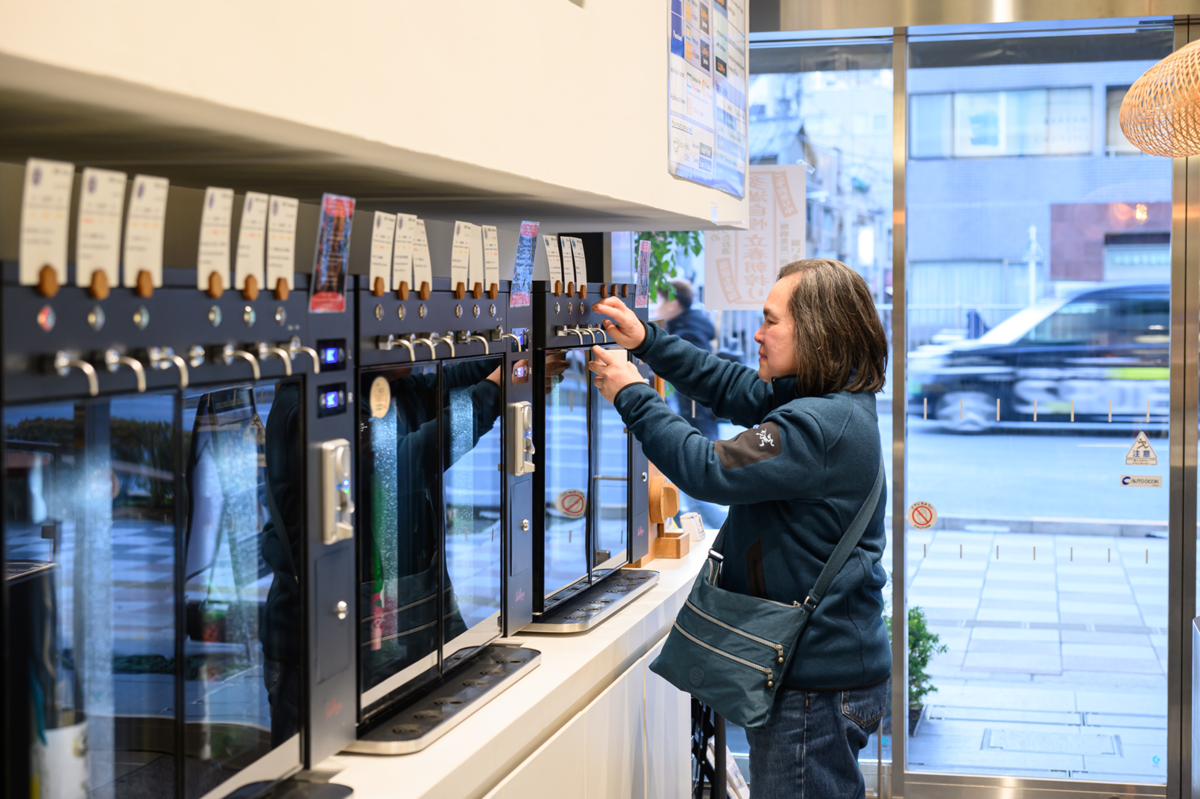 マシンを使った飲み比べを楽しむ外国人観光客