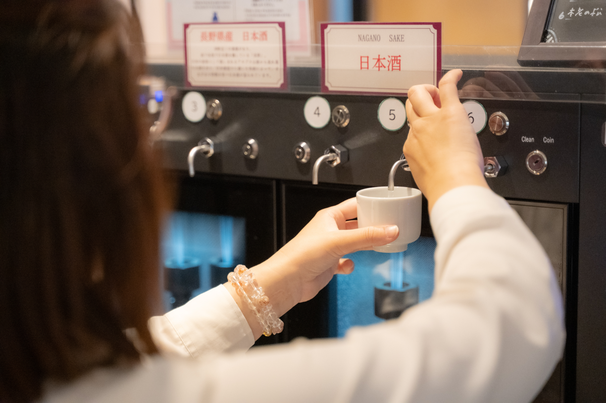 アンテナショップで日本酒飲み比べをする女性