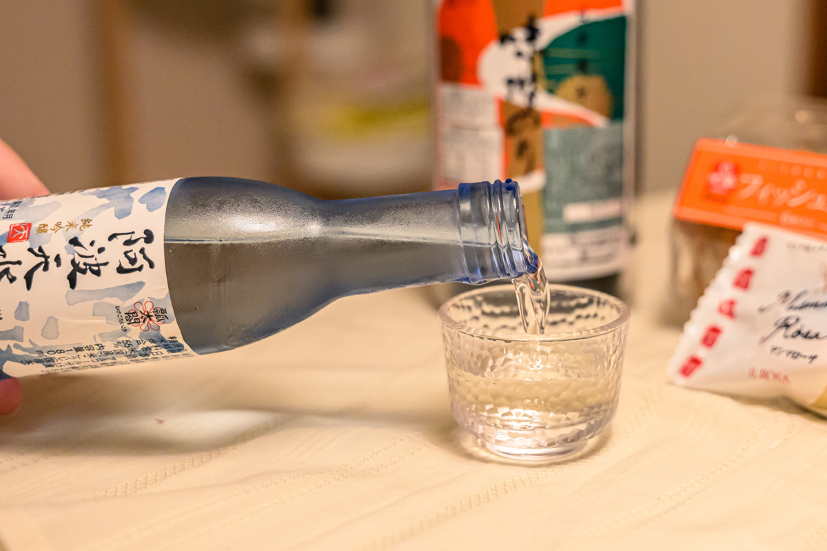日本酒をおちょこに注いでいる