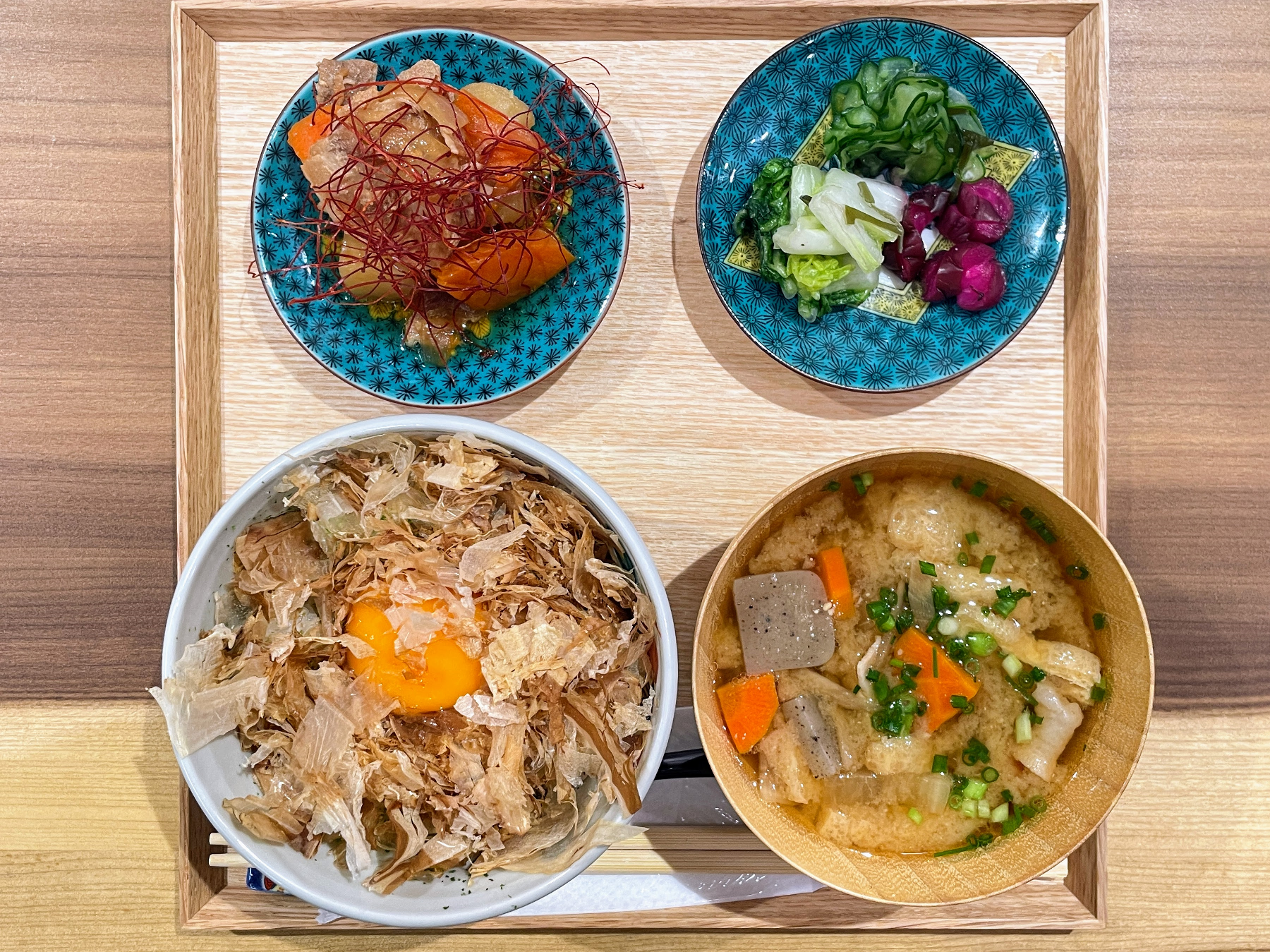 木製の四角いお盆の上に丼、お椀、小皿が並ぶ