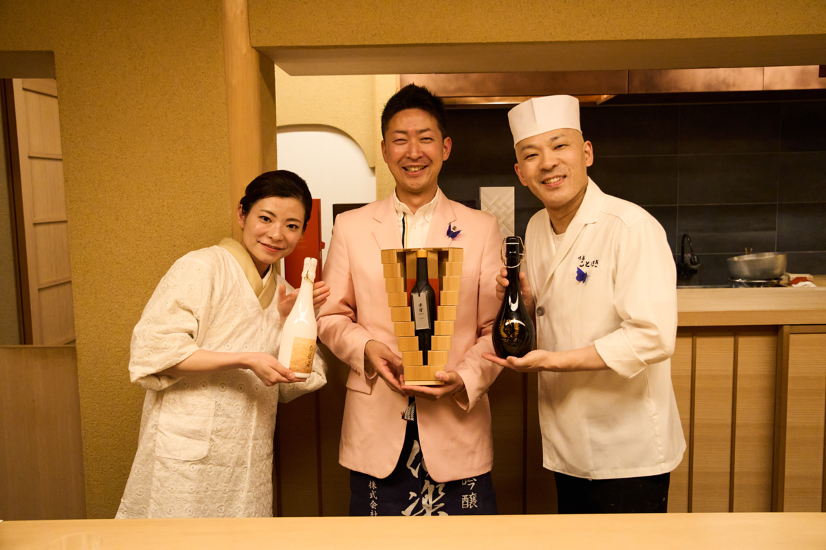日本酒ボトルを持っている3人