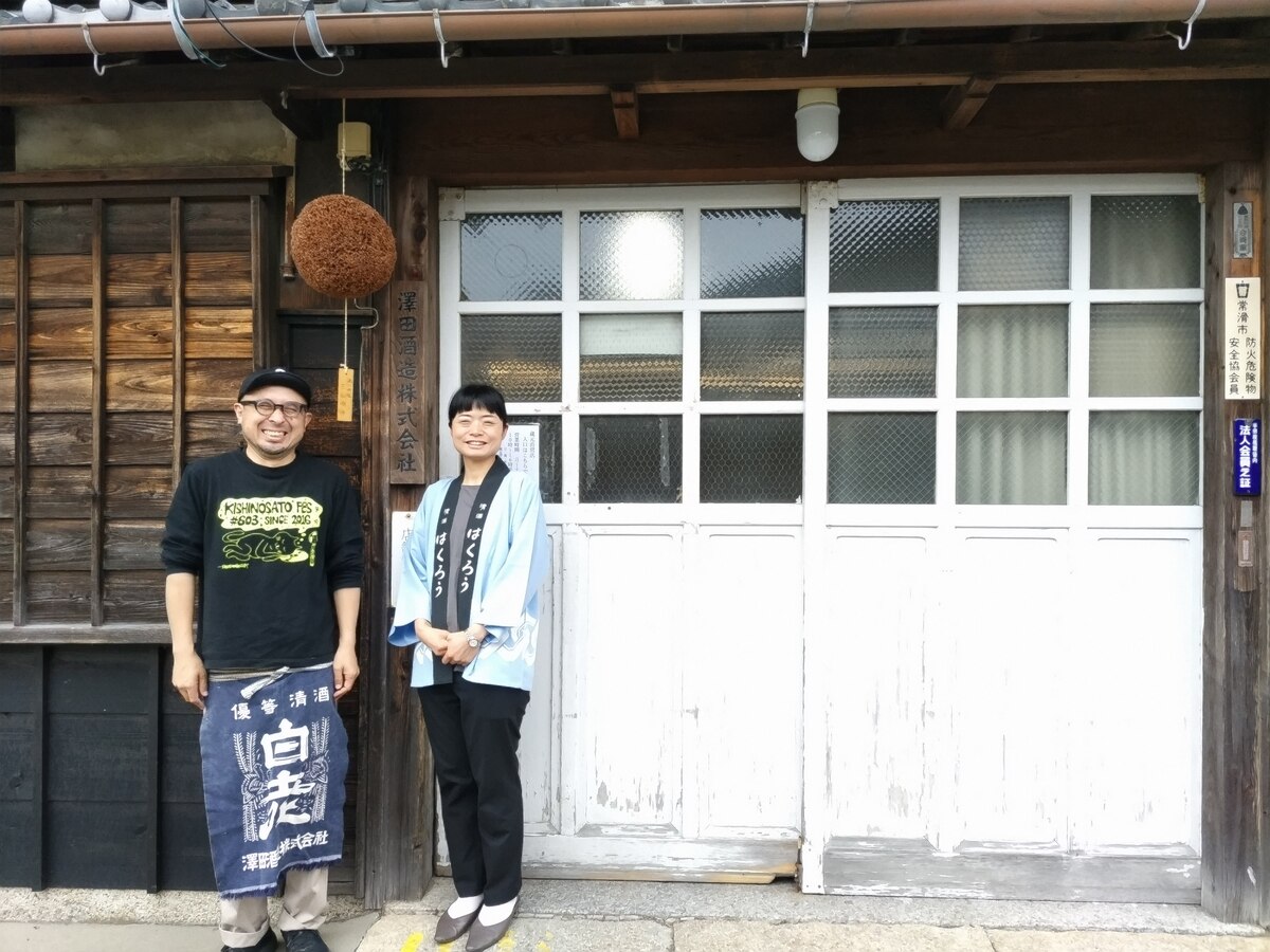 a man and a woman in front of a brewery