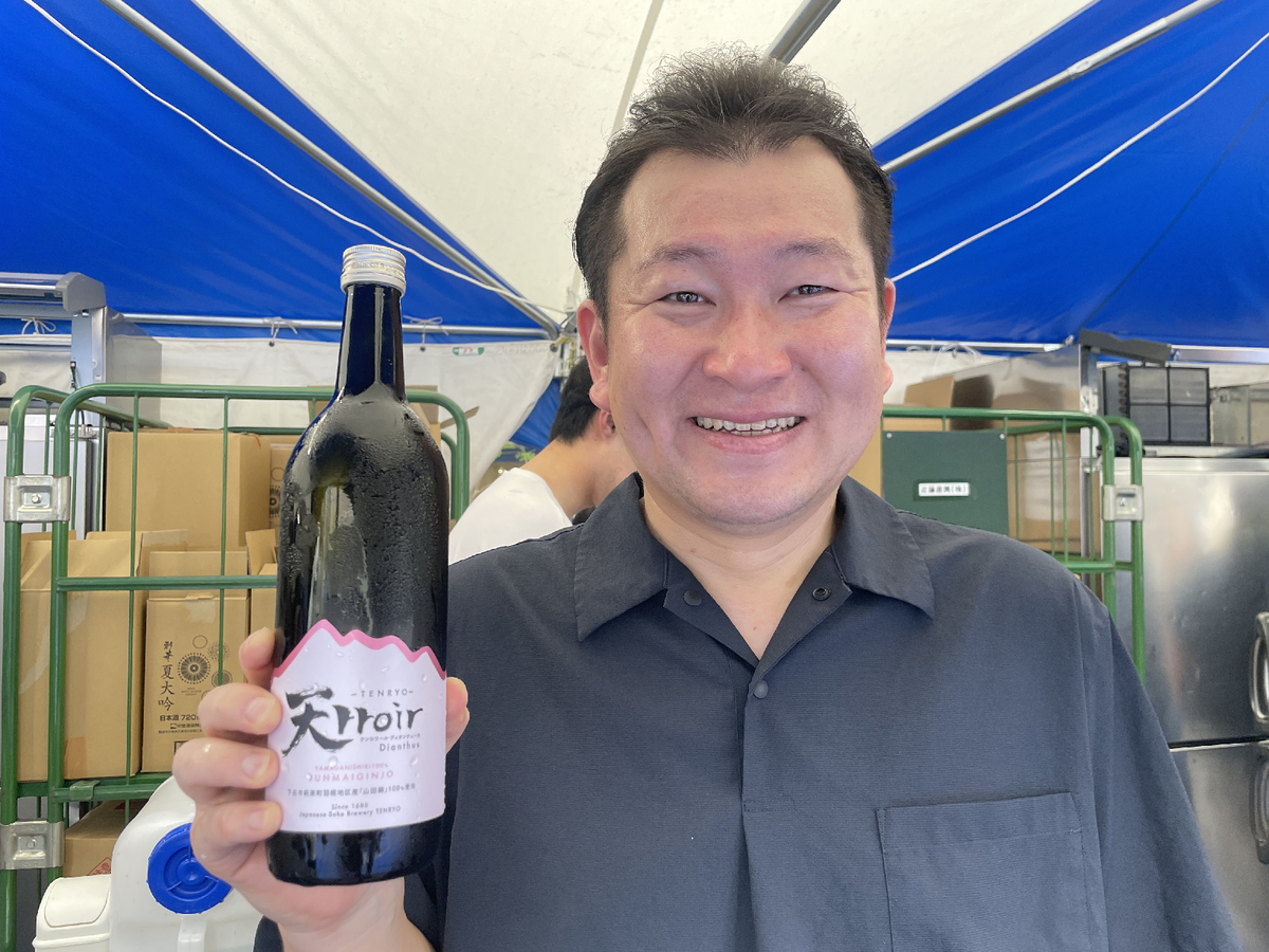 日本酒の瓶を手に持つ男性