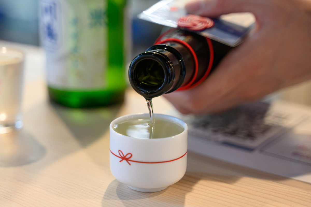 おちょこに日本酒を注ぐ手元