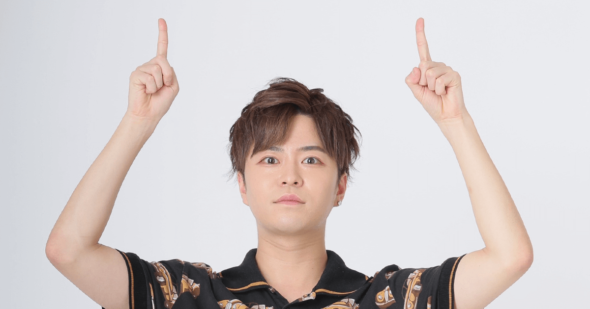 指で上を指す男性