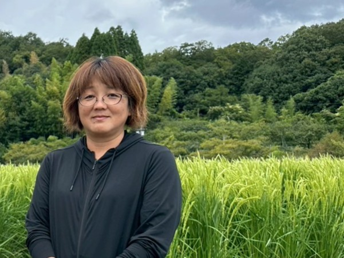 田んぼの前に立つ女性