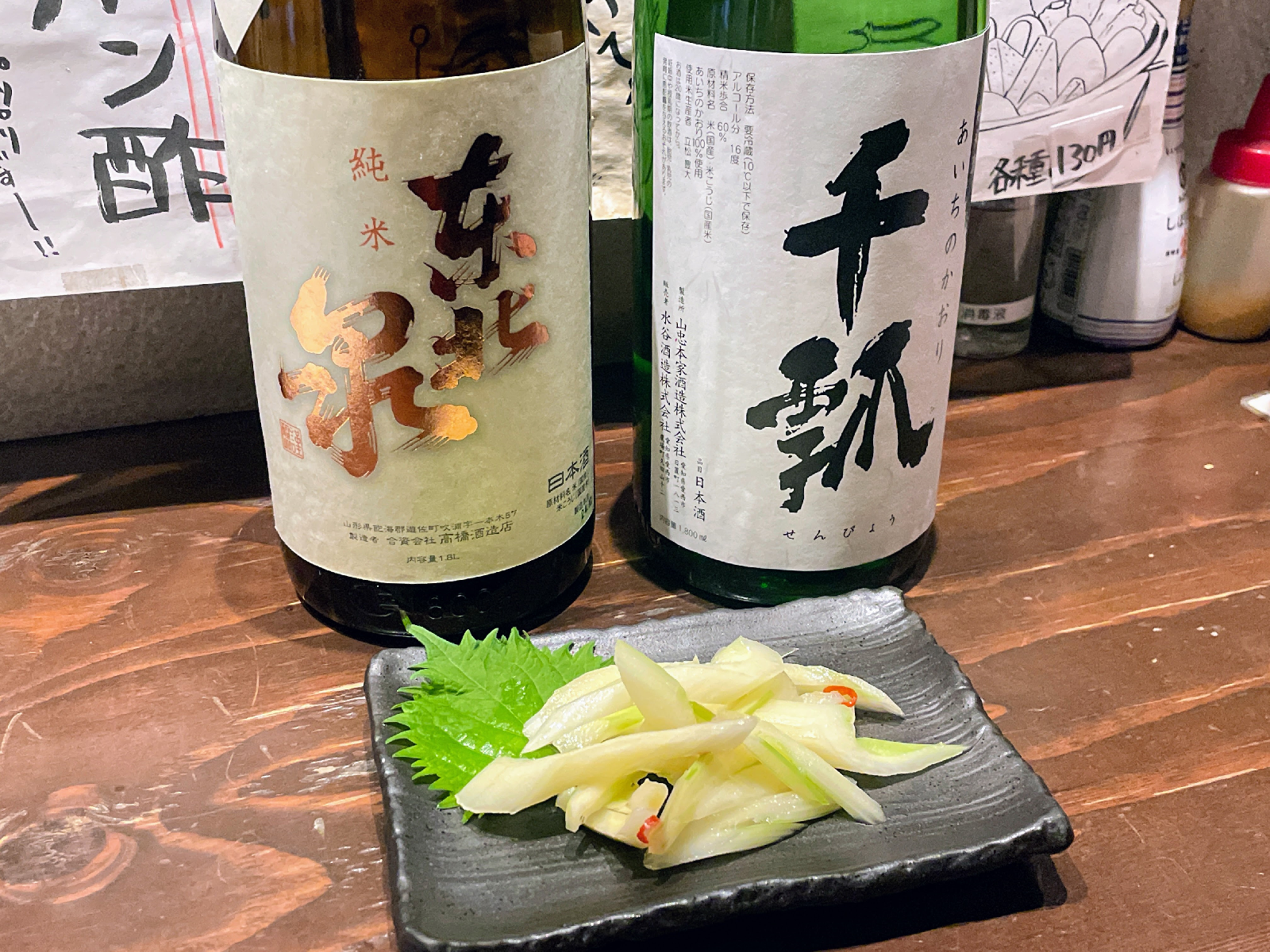 日本酒の瓶2本、さらに盛られたセロリの漬物