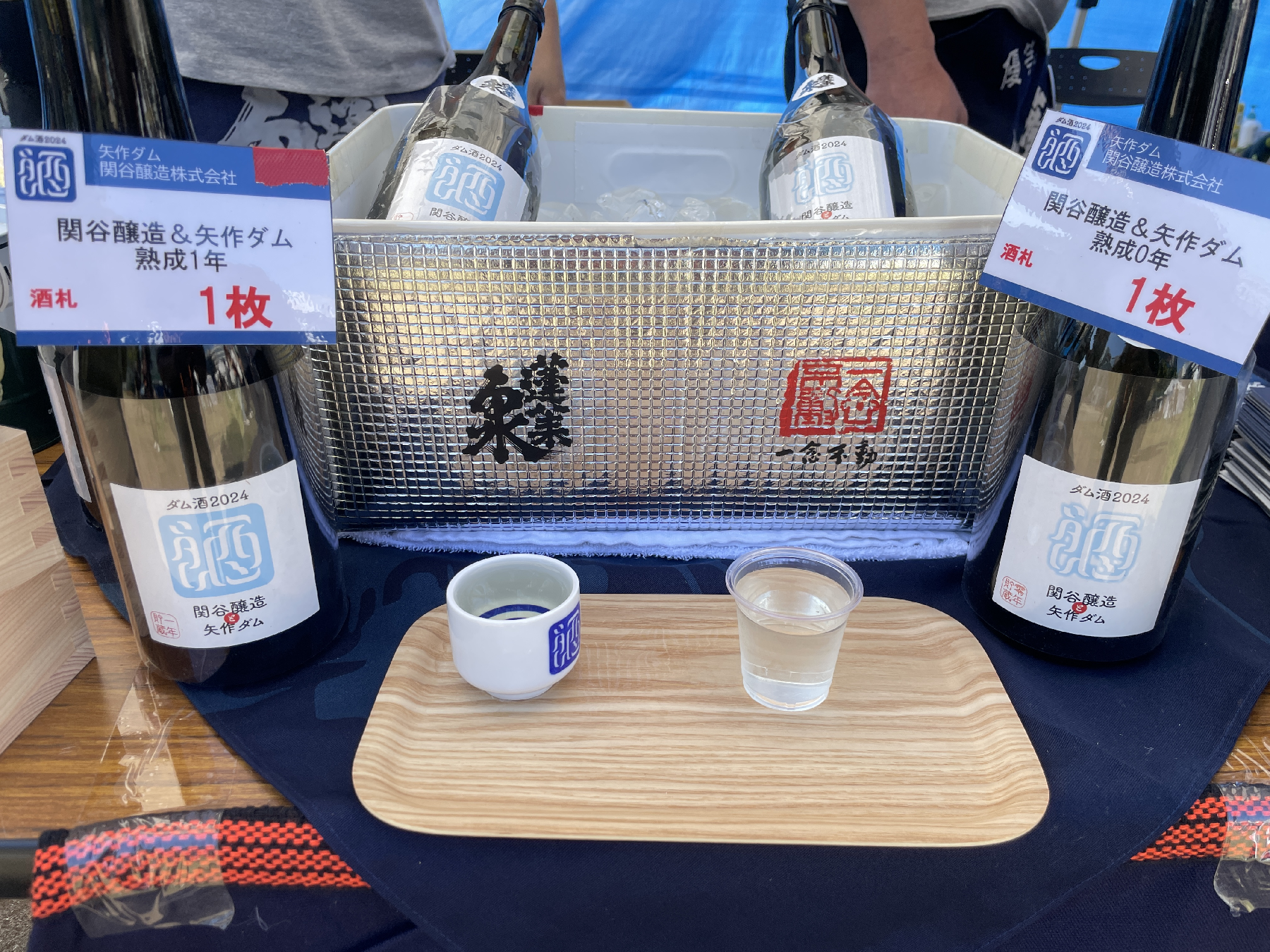 トレイの上に載ったお猪口とプラスチックカップ、日本酒の瓶