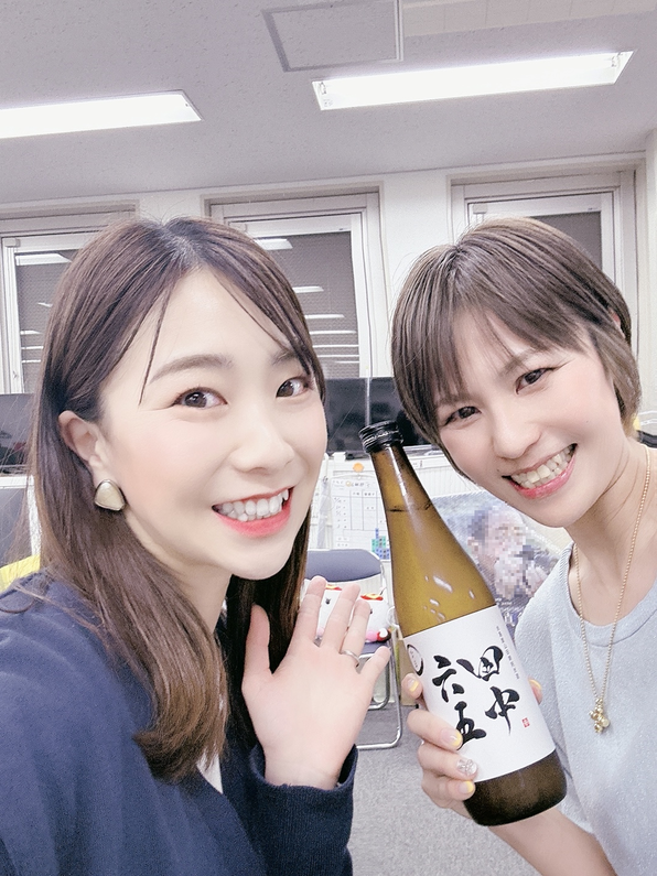 日本酒を持つ女性とポーズをする女性